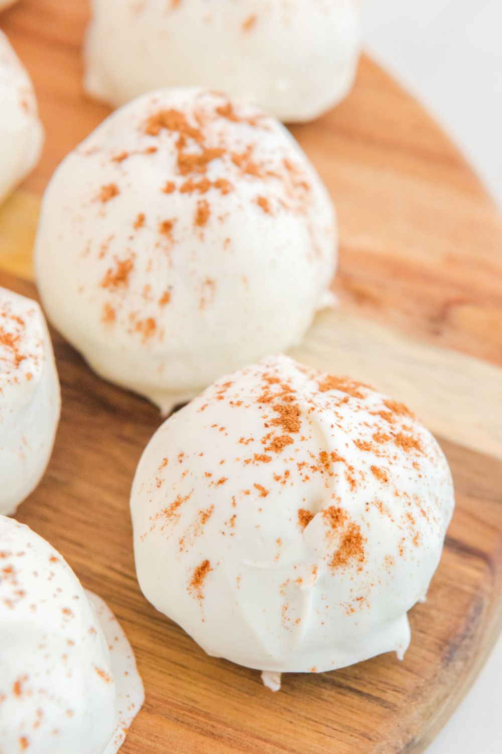 pumpkin spice cake balls on a wooden cutting board