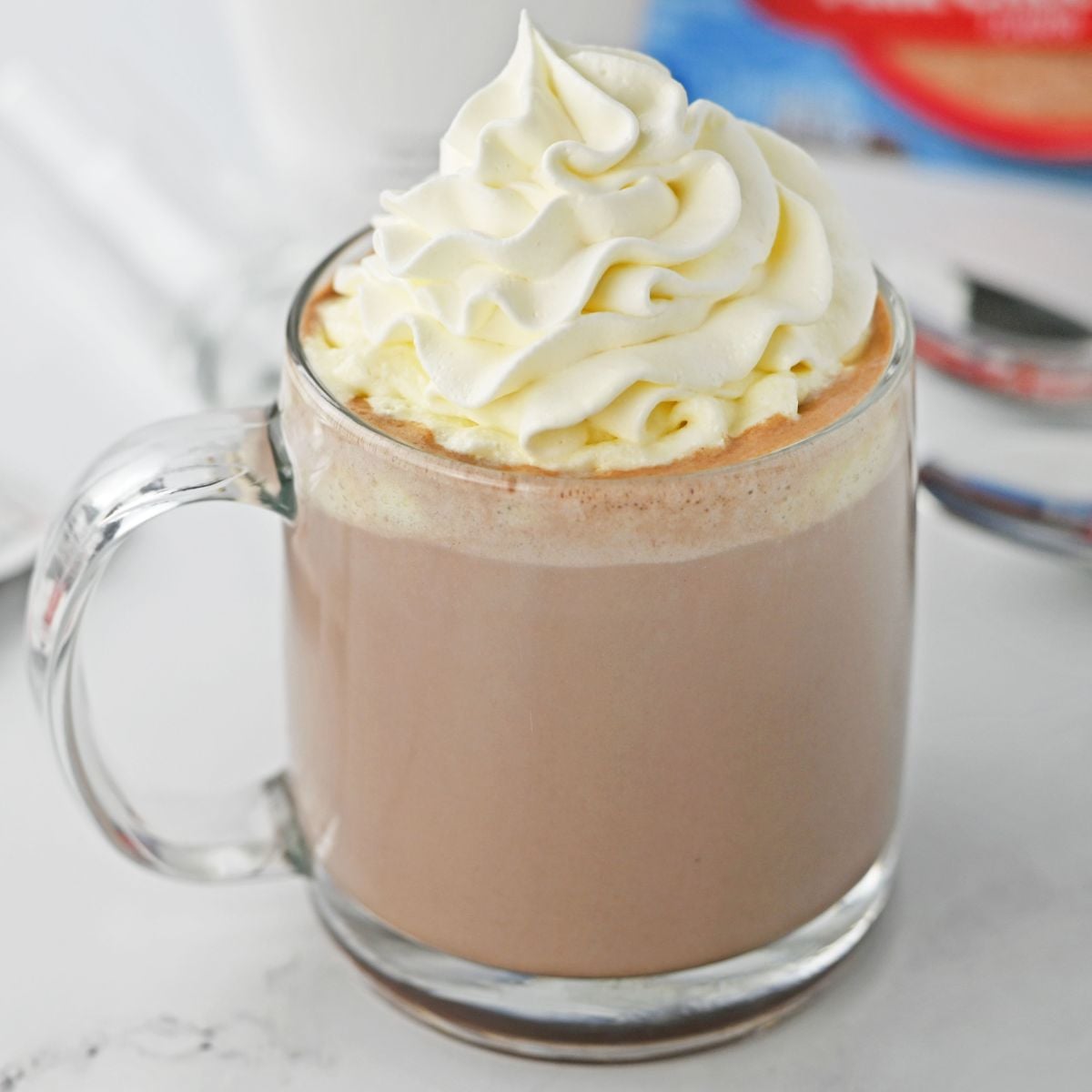 rumchata hot chocolate on a white table topped with whipped cream