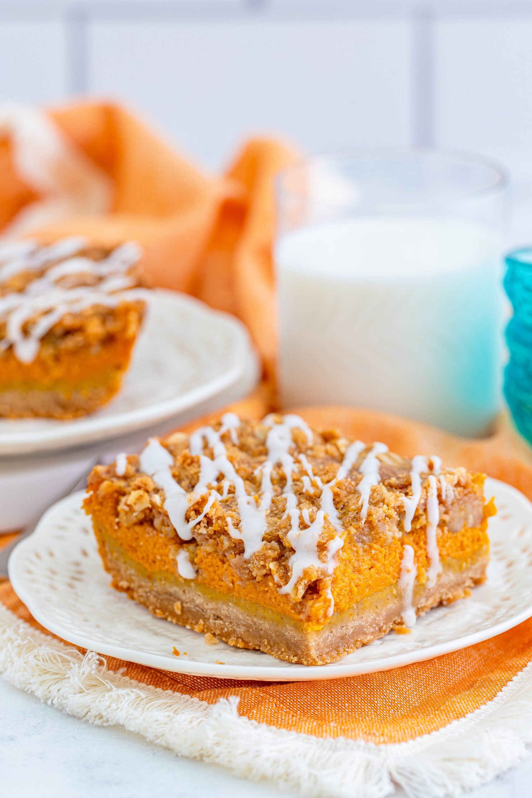 Pumpkin Streusel Bars on a white plate with a glass of milk next to it
