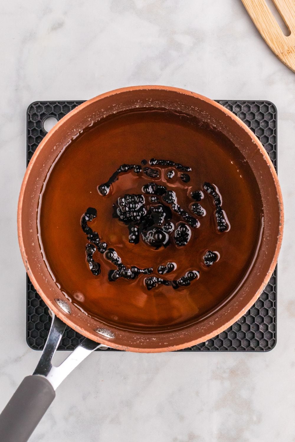 black food coloring added to pan of candy coating for apples