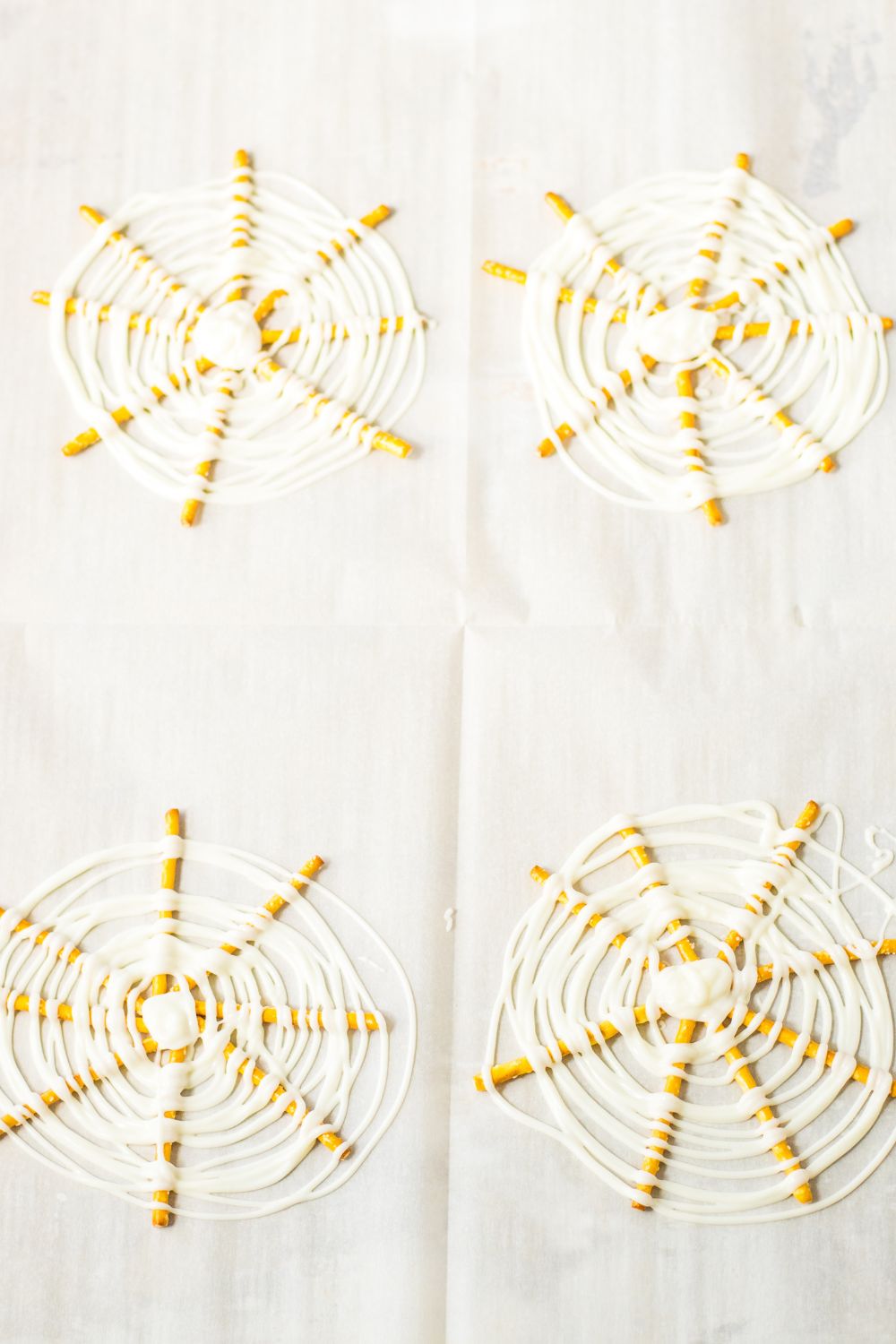 white chocolate swirled in circles on top of the pretzels to mimic a spider web
