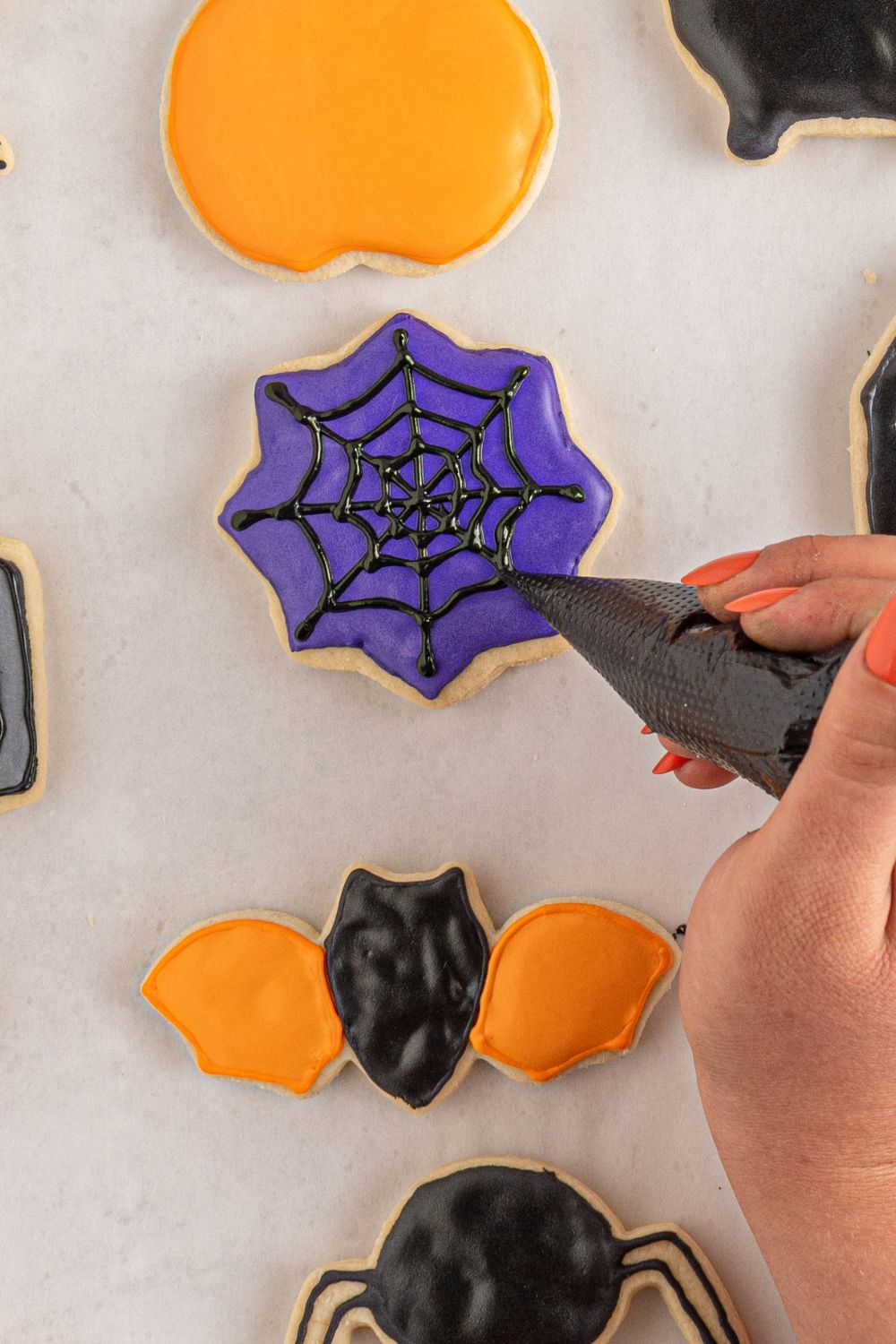 drawing spider web on sugar cookie 