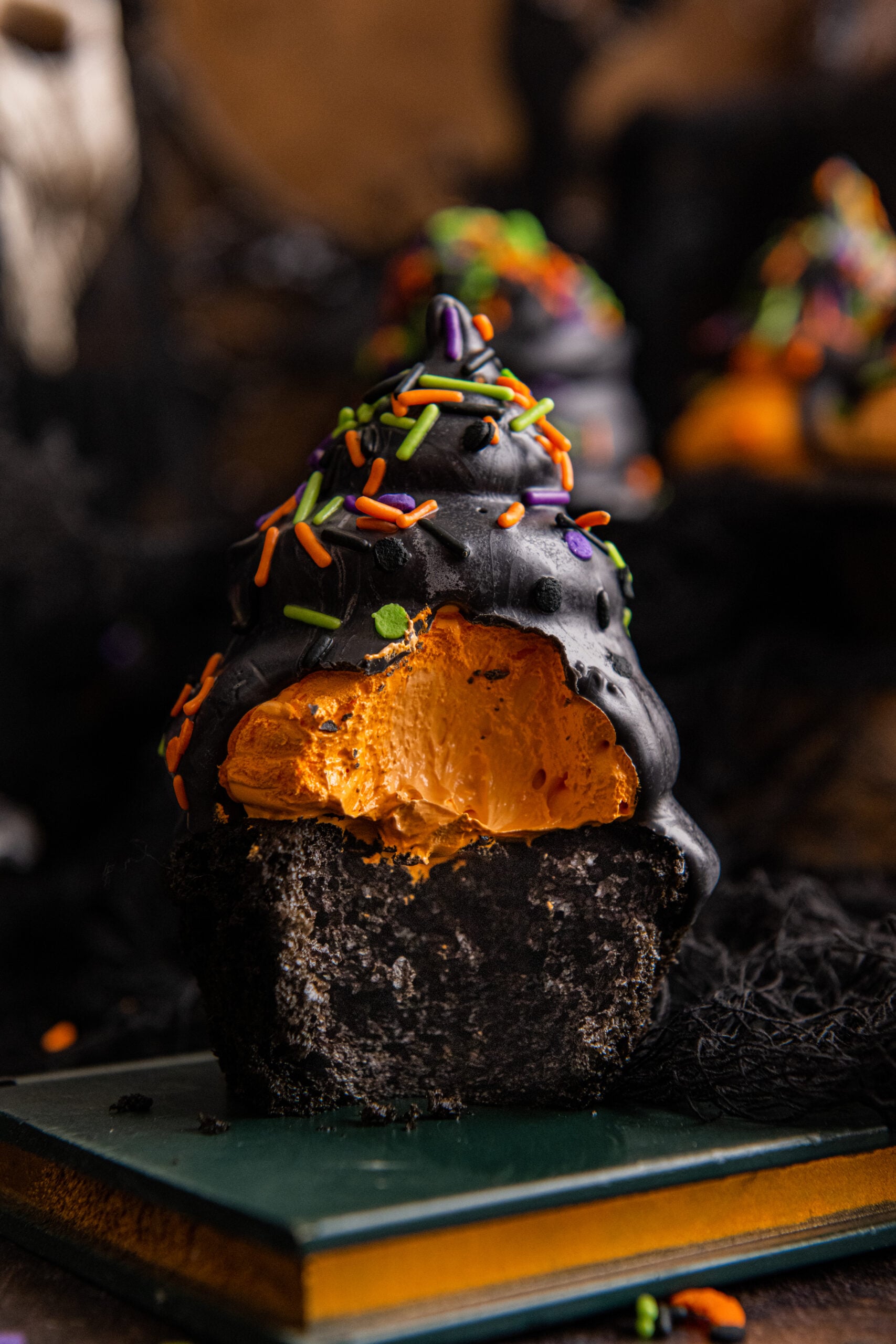 bite taken out of the halloween cupcake on a book