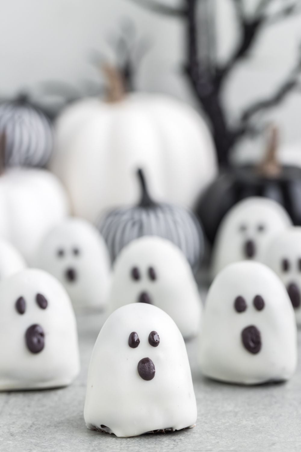 spooky Oreo truffles on table with fabric pumpkins behind them