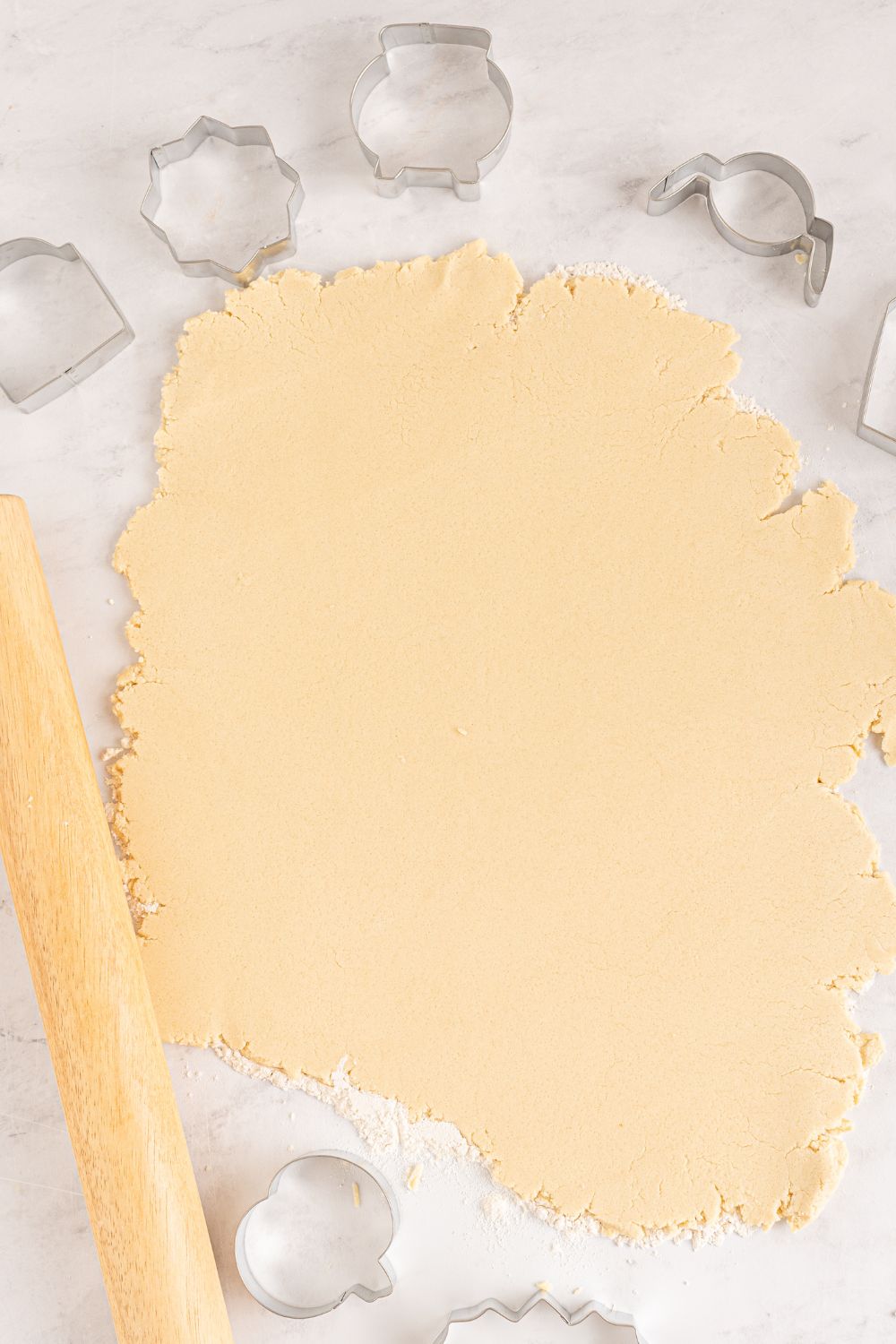 rolled out sugar cookie dough on table 