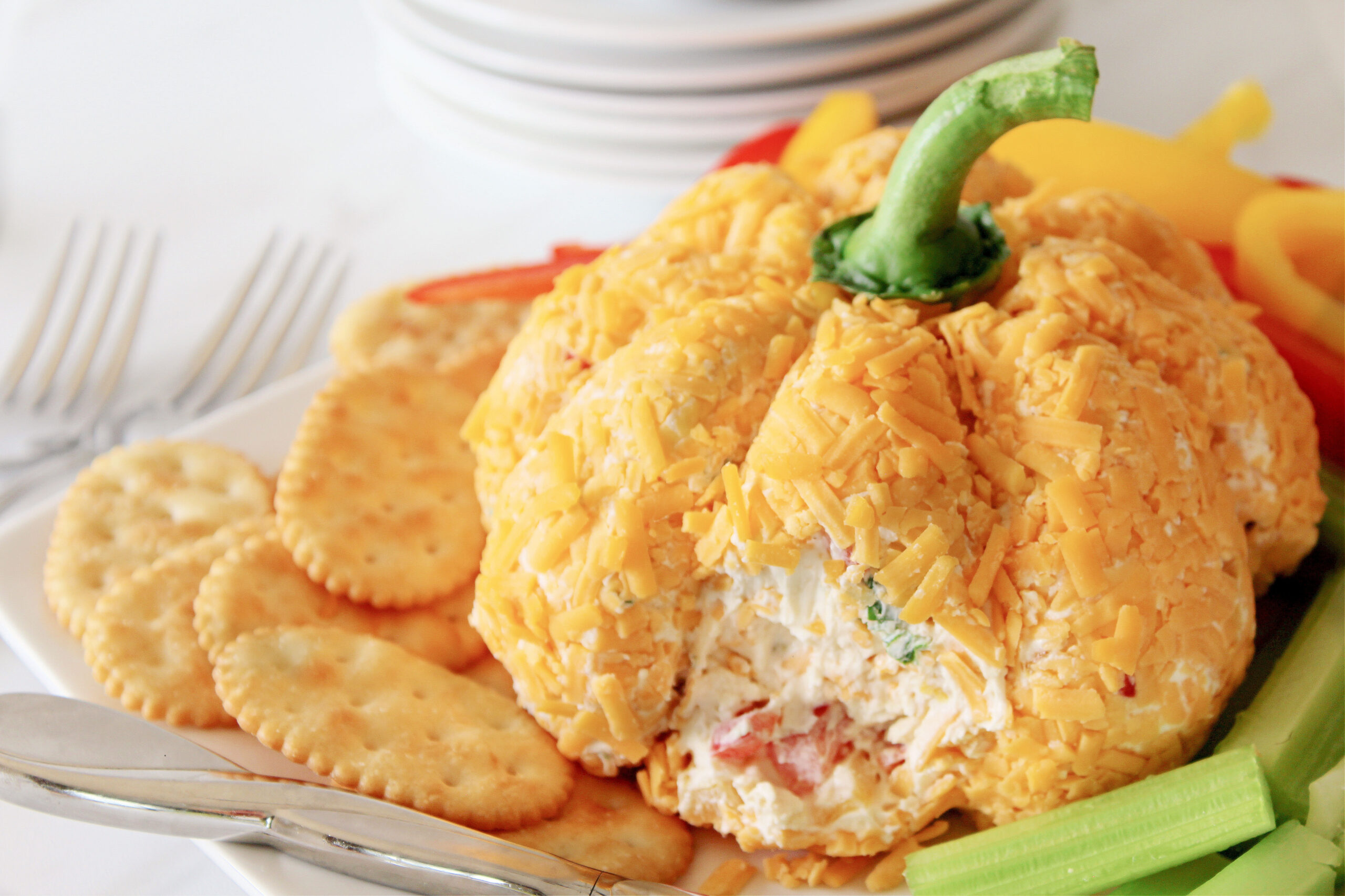 pumpkin cheeseball with part removed from cheeseball to show center