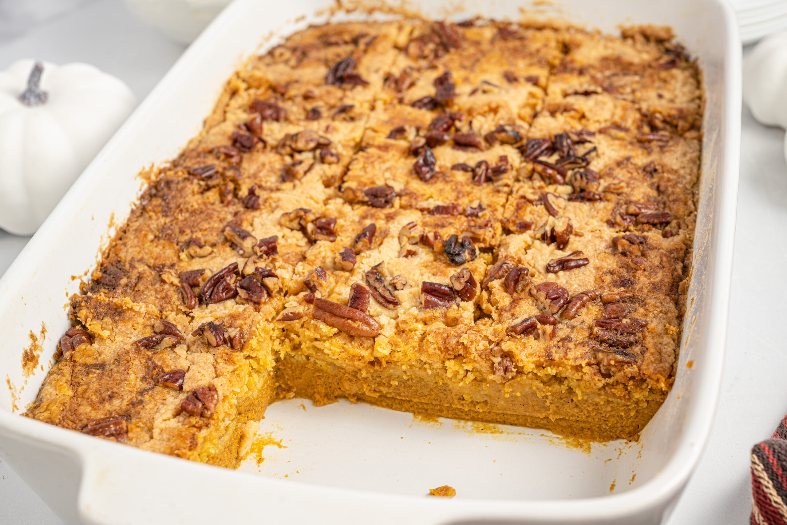 Pumpkin Dump Cake in a white baking dish with slices removed