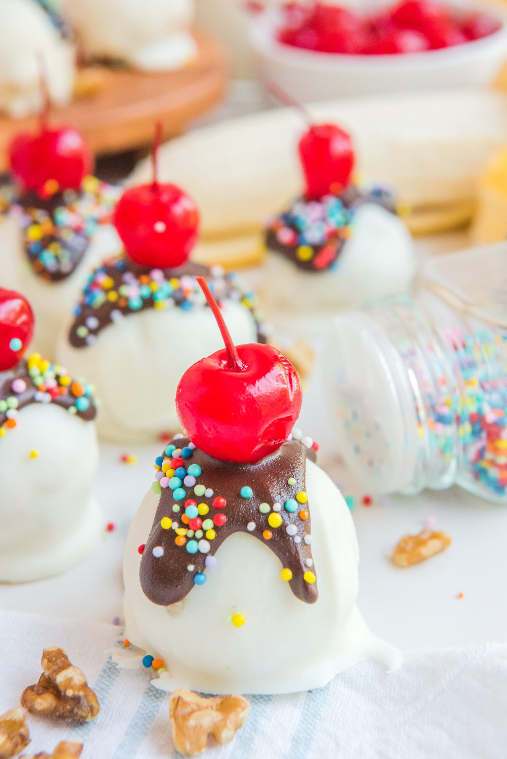 Front view of Banana Truffles surrounded by nuts. and sprinkles