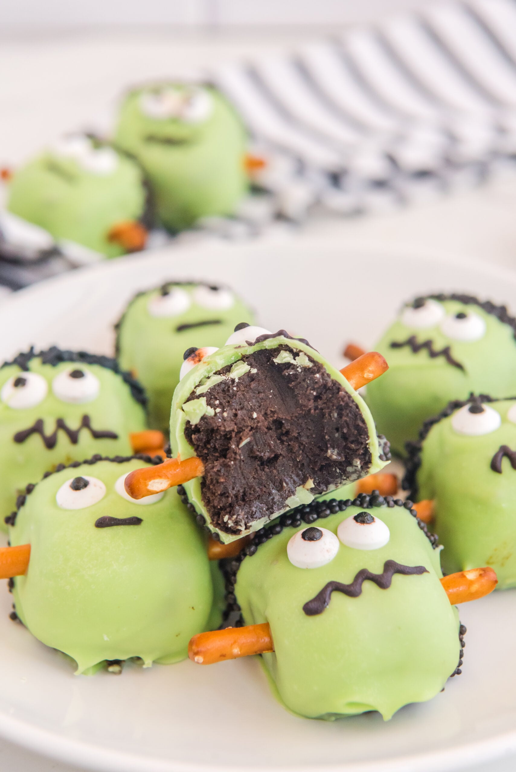 a pile of the Frankenstein Oreo balls with a bite taken out of the top one