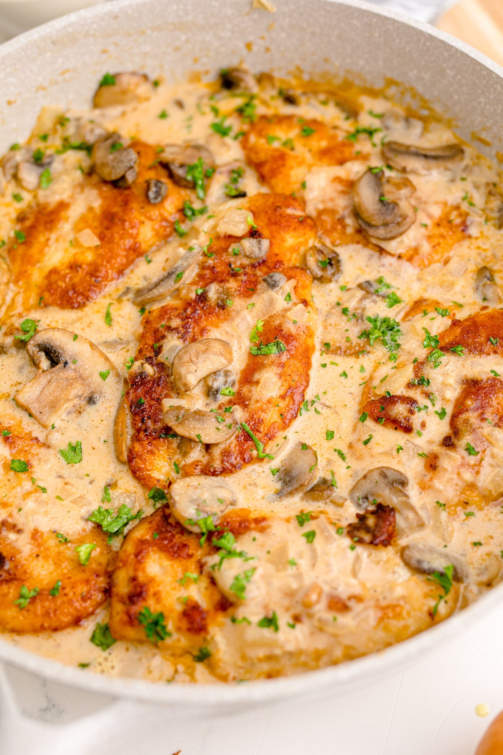 close up shot of the Chicken Marsala in a white skillet 