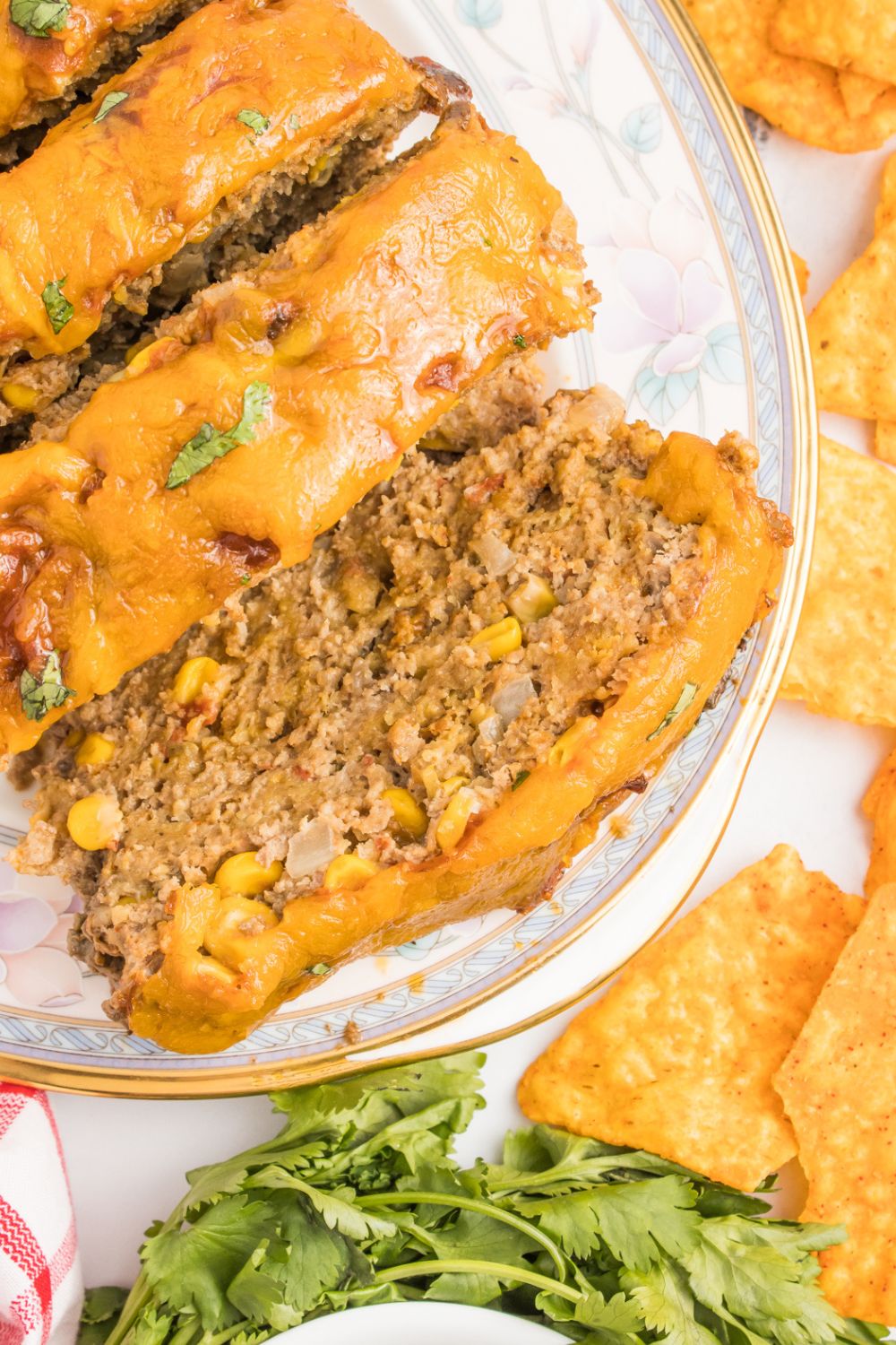 meatloaf on plate with chips and such around the plate