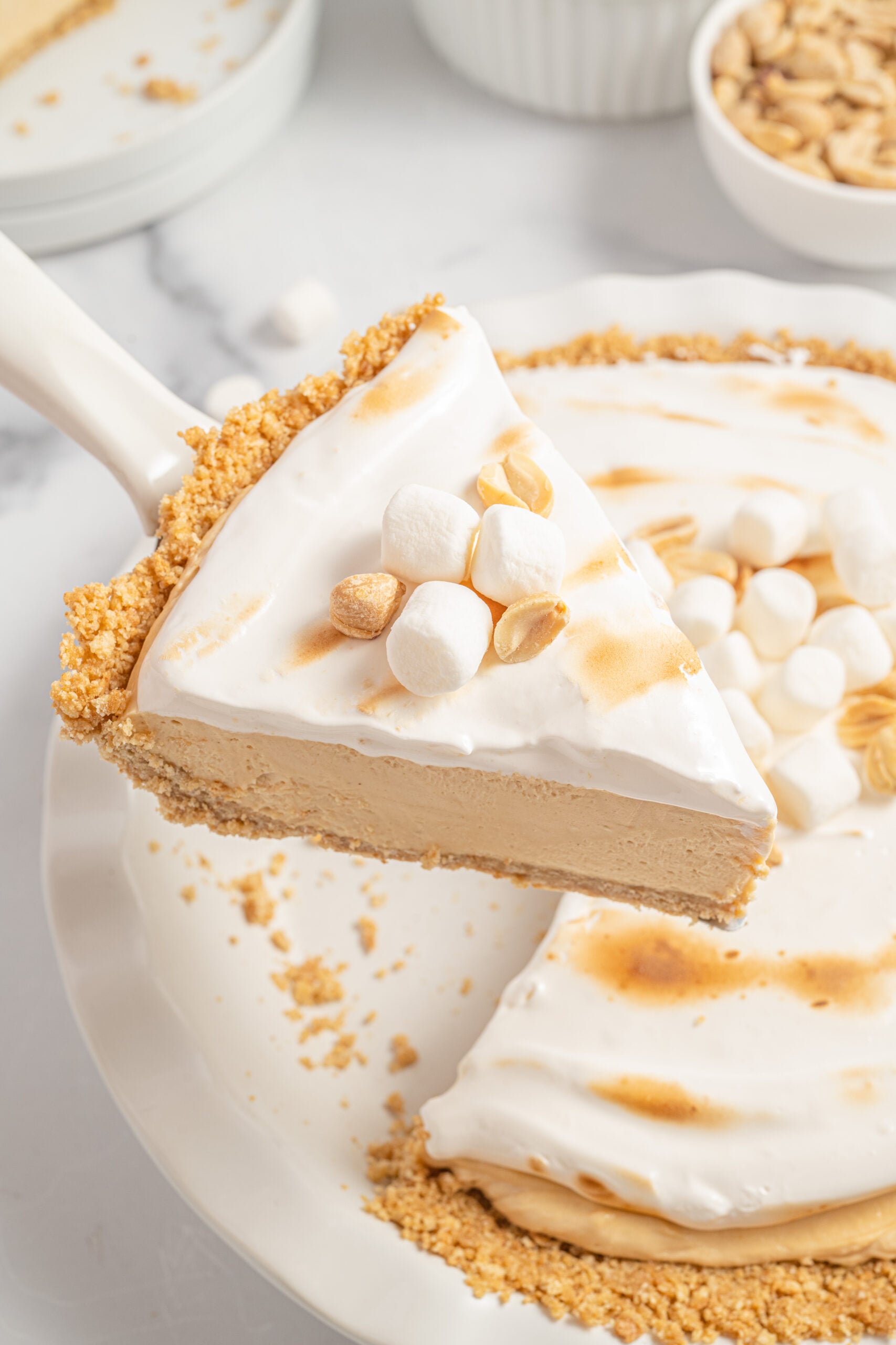 Fluffernutter pie slice being lifting up from the white pie dish