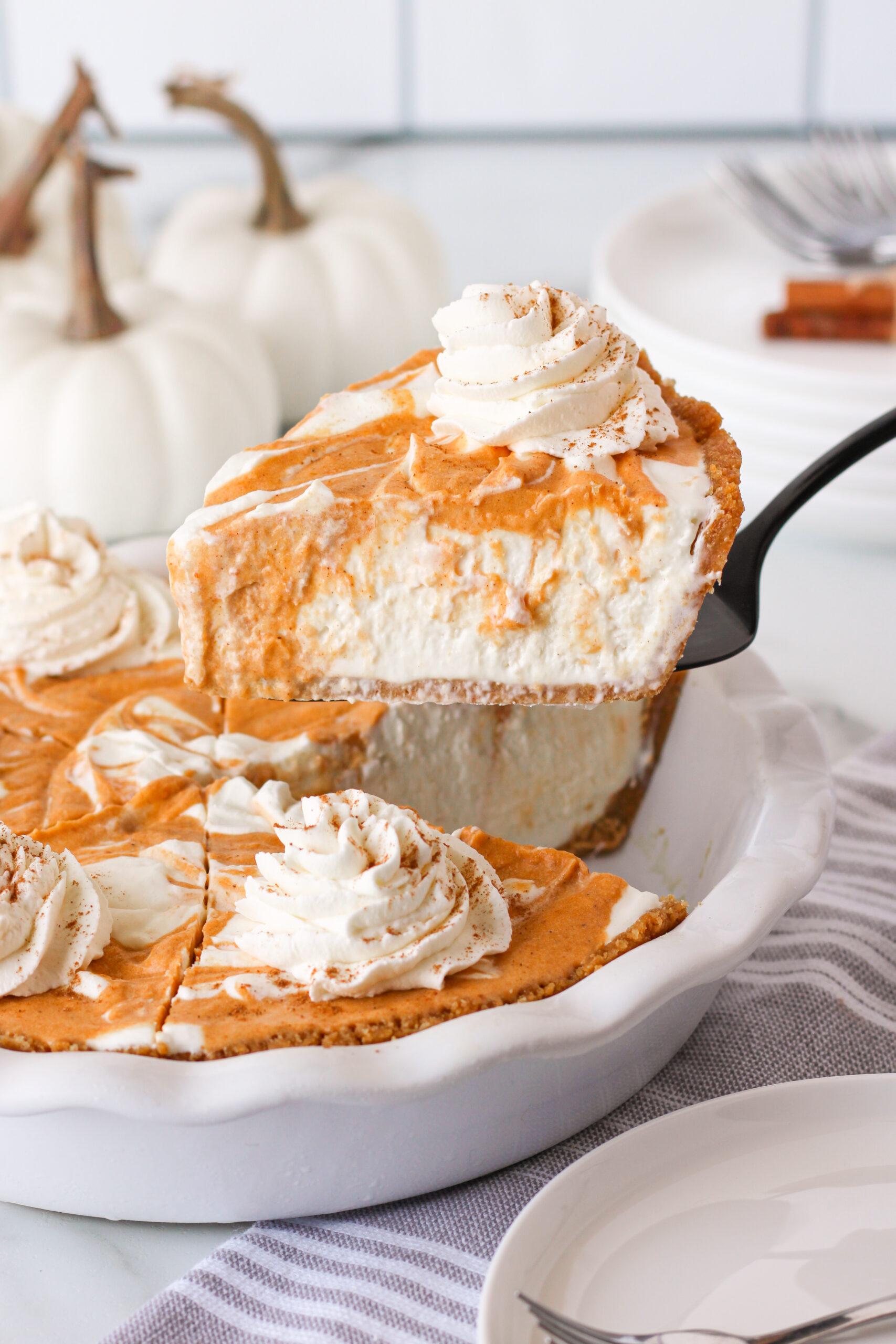 Pumpkin Ice Cream Pie in a white baking dish with a slice being lifted out