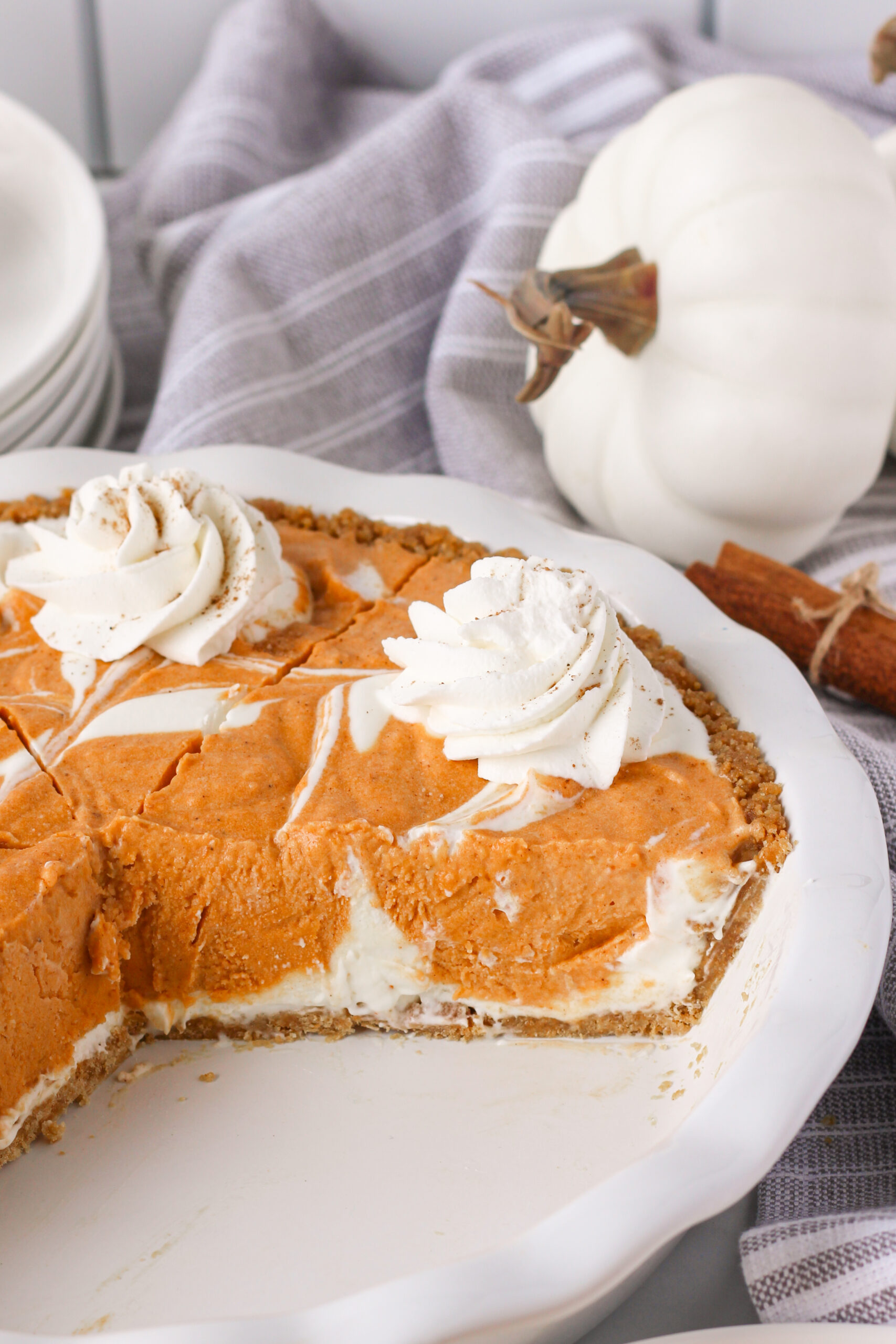 Pumpkin Ice Cream Pie in a white baking dish with a couple of slices missing