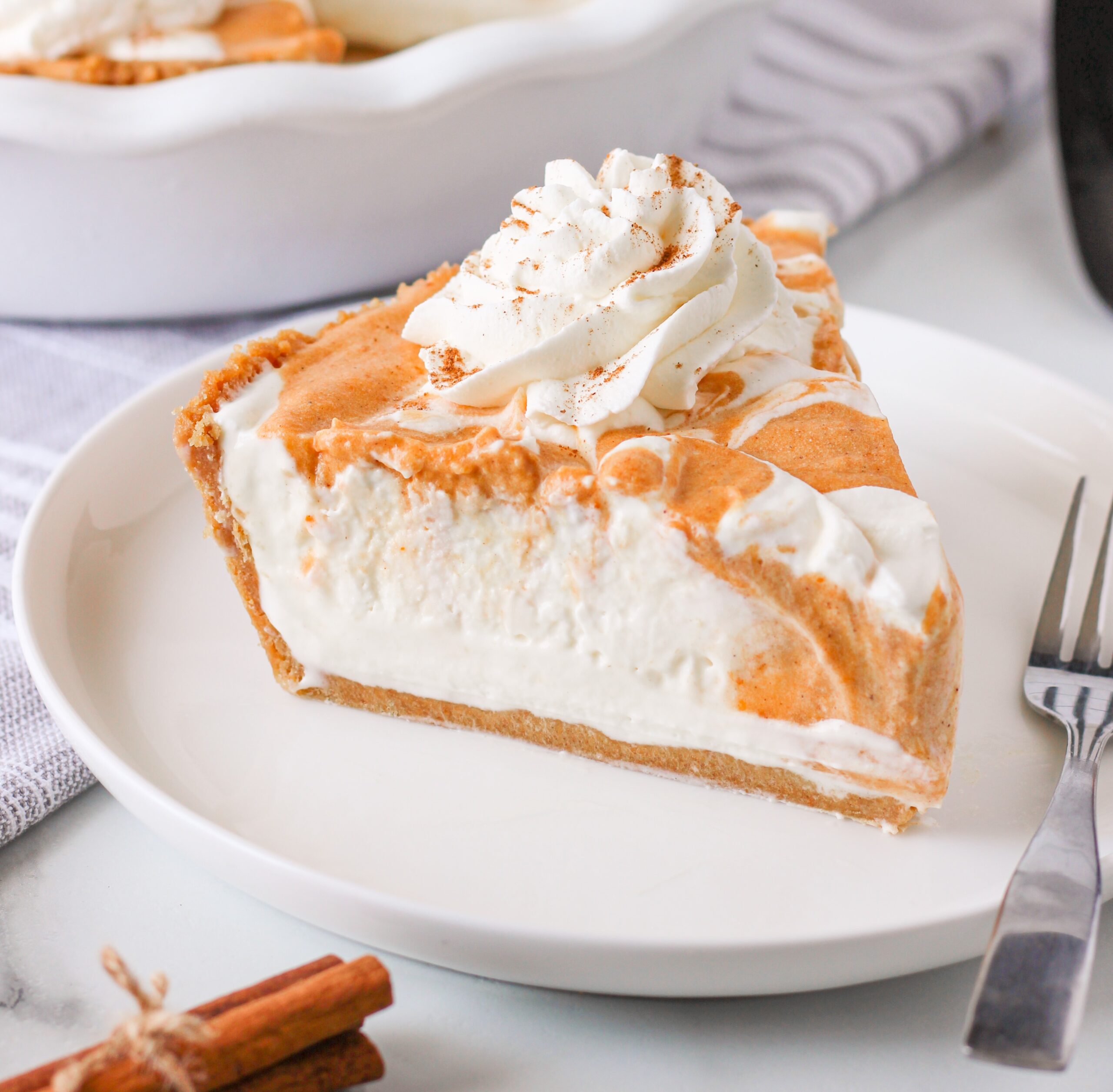 Pumpkin Ice Cream Pie on a white plate topped with whipped cream