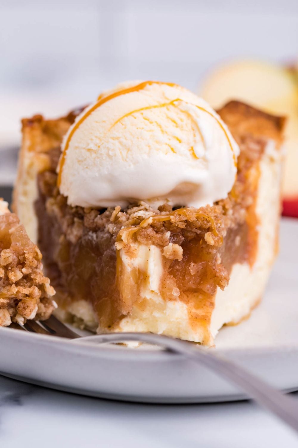 apple cinnamon cheesecake with some bites taken out of it