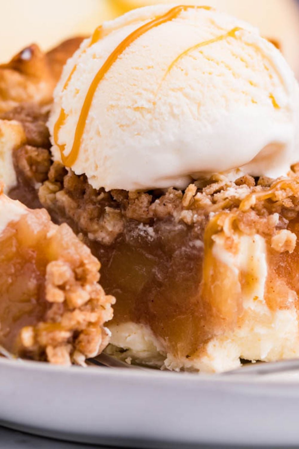 Apple Crumble Cheesecake Pie slice on plate with a bite taken out of it 