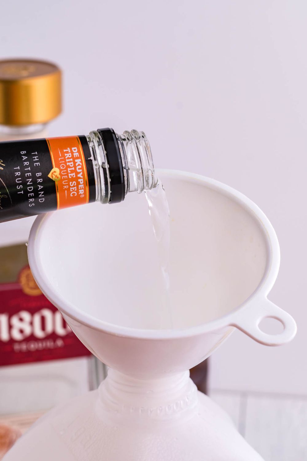 triple sec pouring into a funnel