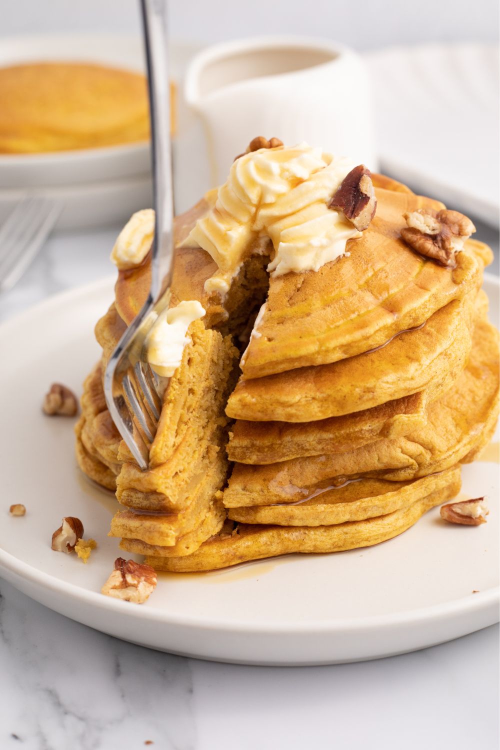slice and pancakes stacked on plate