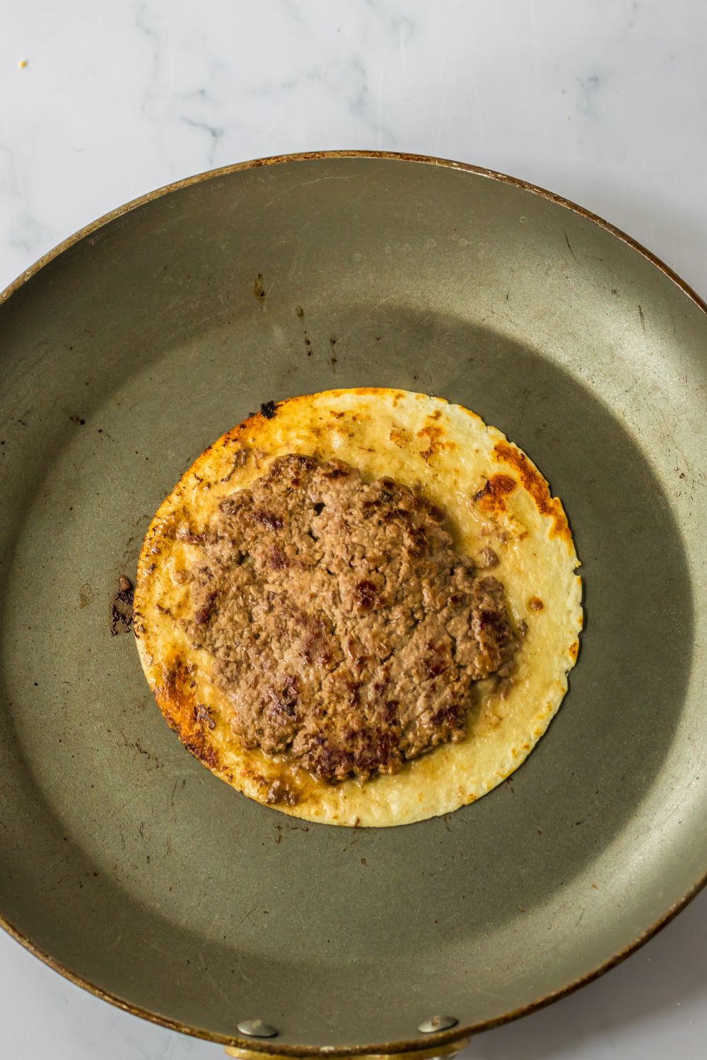 crispy tortilla with a burger patty on top