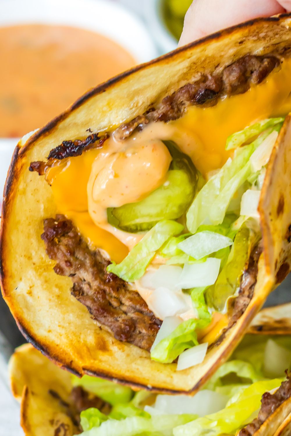 holding big mac taco in hand