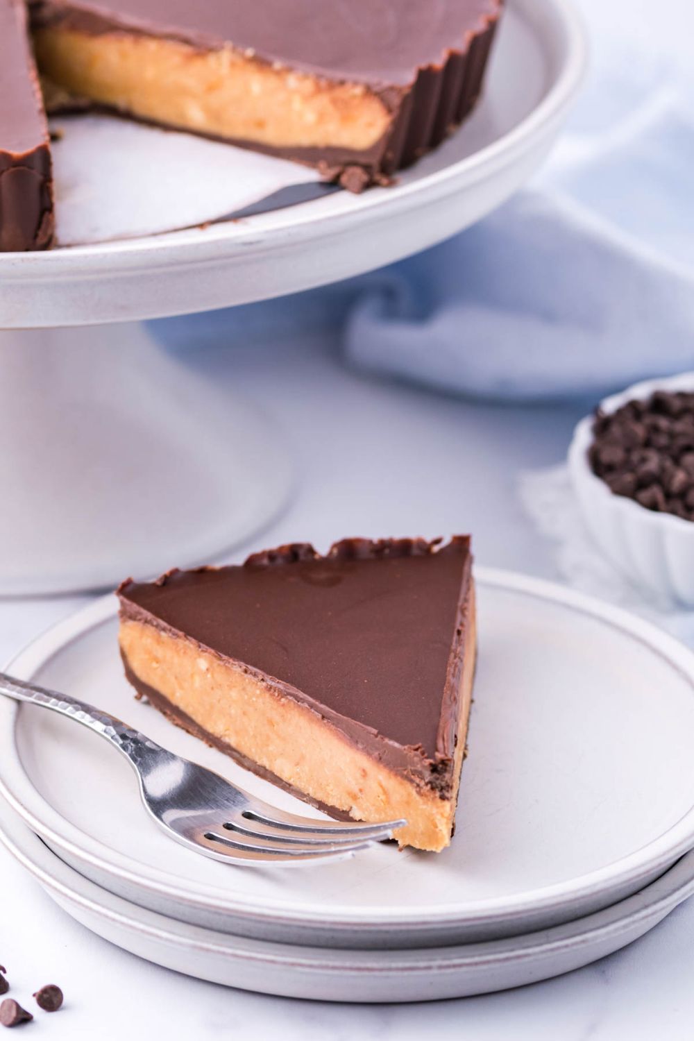 Giant Reese's Cup Pie on serving tray with slice on plate with fork by it 