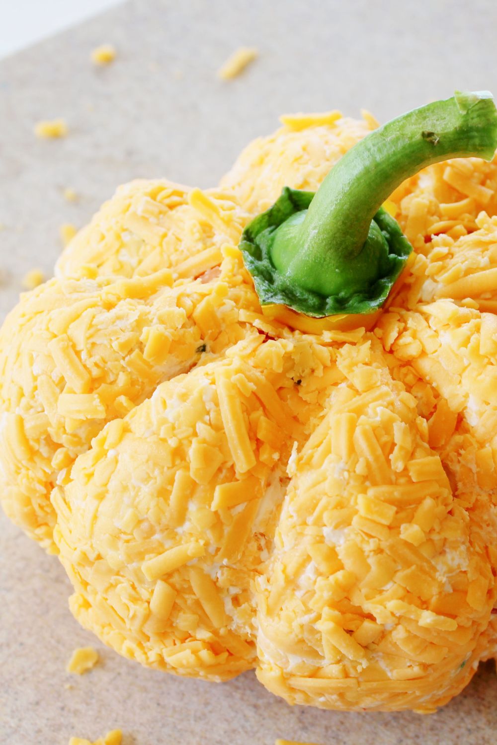 pumpkin shaped cheeseball with a pepper stem placed on top