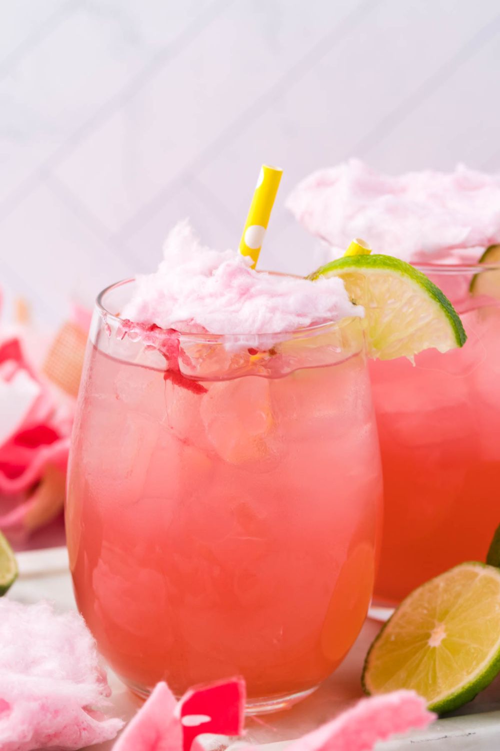 margaritas on table with straw and lime wedges for garnishment