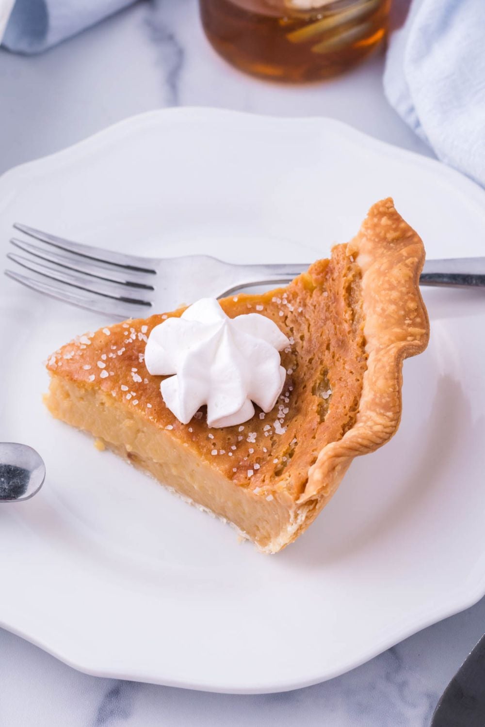 pie on plate topped with whipped cream and fork on side