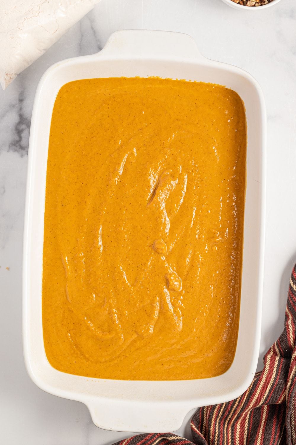 raw pumpkin cake batter in a baking dish