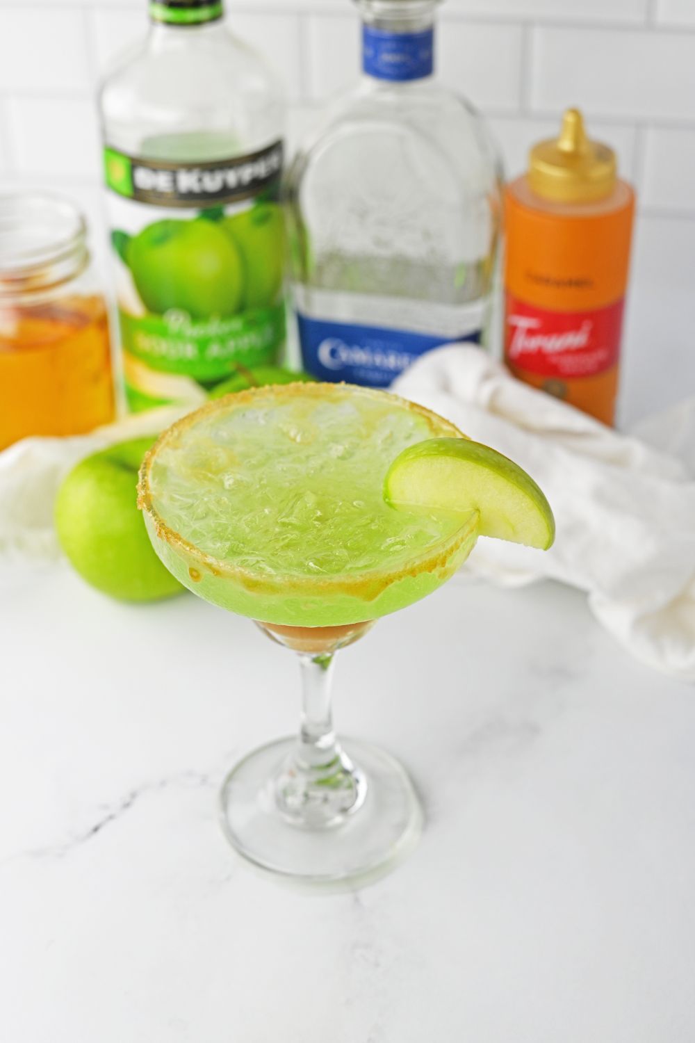 overhead view of margarita with apple wedge on it on table