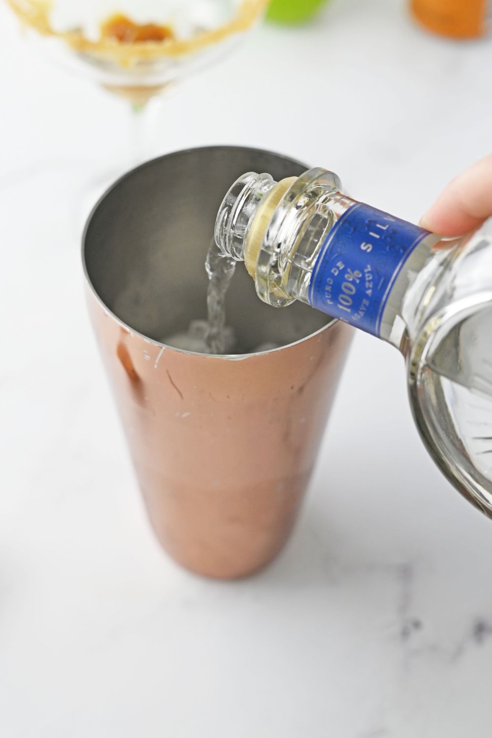 pouring teuila into a shaker