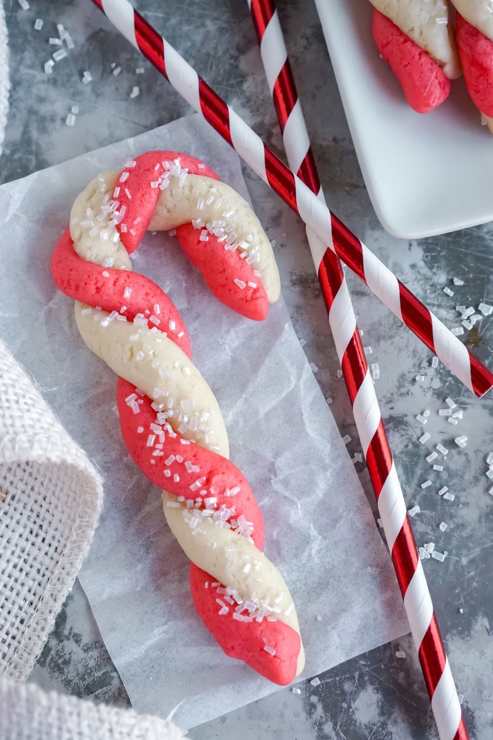Candy Cane Cookie on a table with colored straw