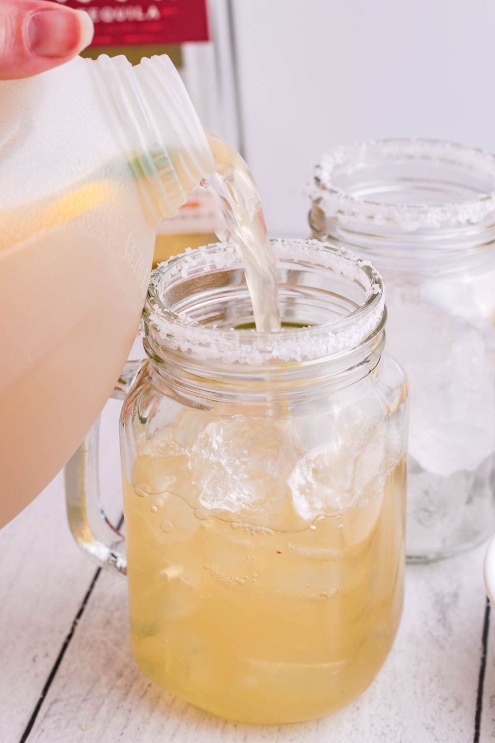 pouring margarita into a mason jar
