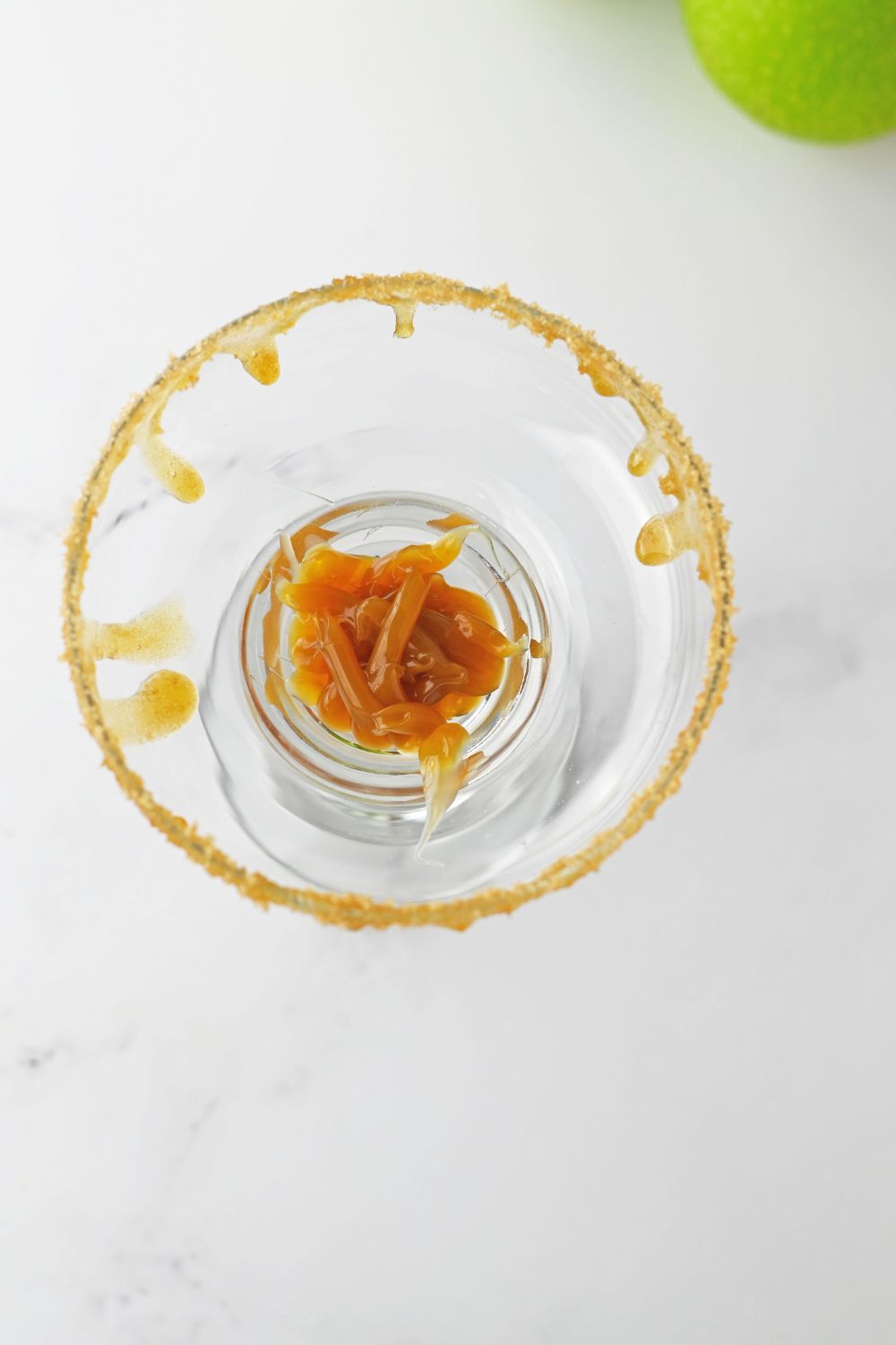 caramel sauce in the bottom of a margarita glass 