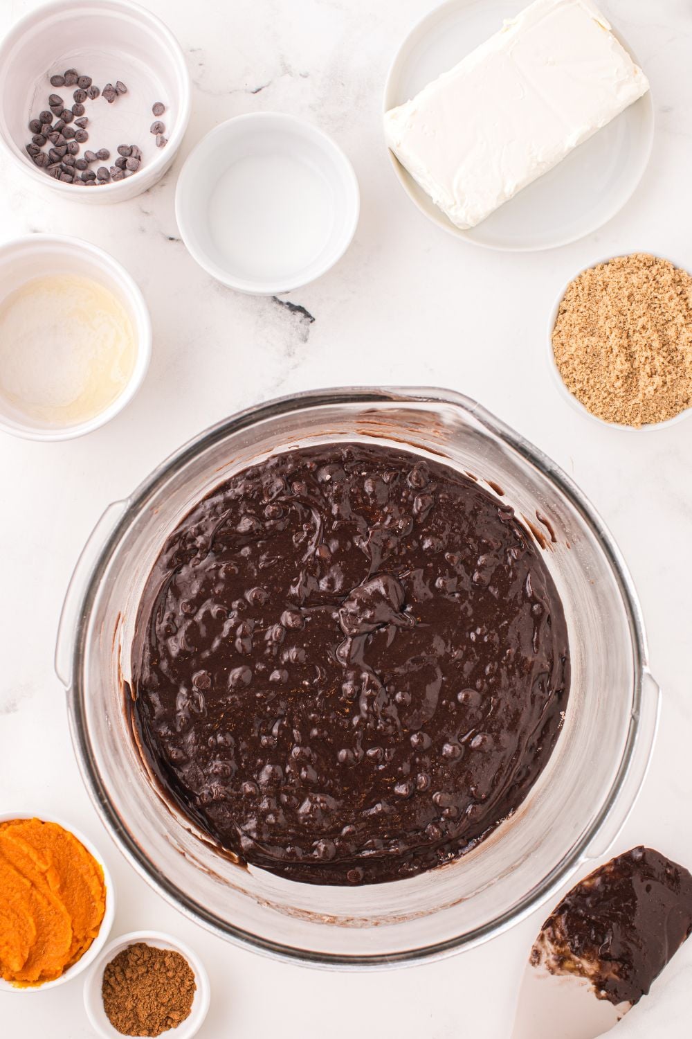raw brownie batter in abowl with ingredients around it