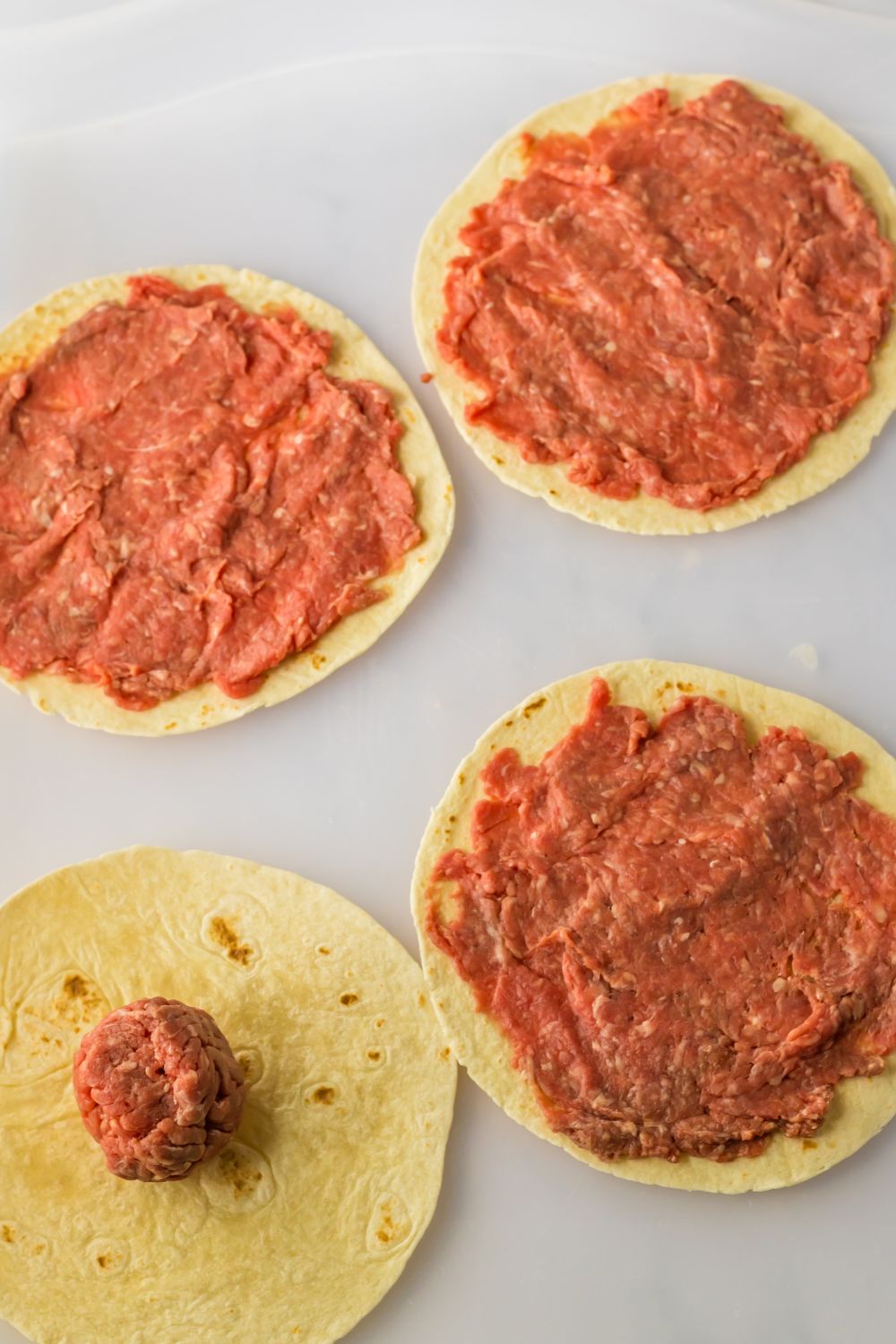 flour tortilla with burger smashed on the tortilla for smash tacos