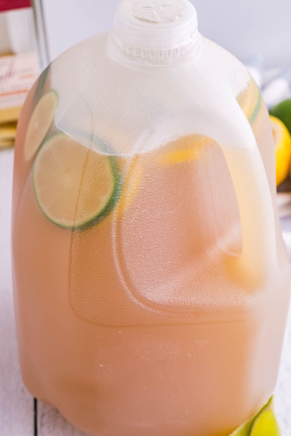 Gallon Margarita sitting on table with lime wedges around it