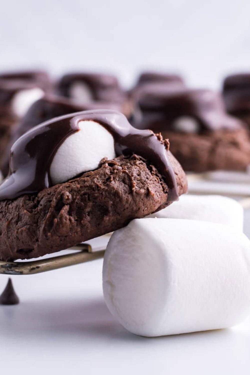 marshmallow and chocolate cookies sittig on table with a marshmallow underneat it