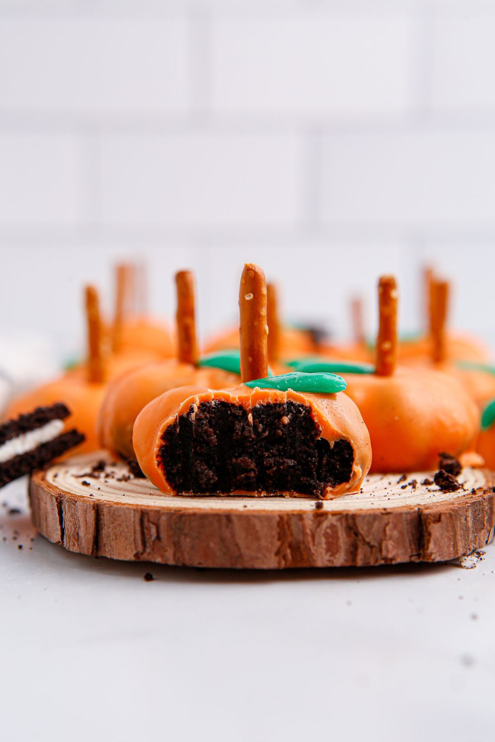 pumpkin oreo balls on a wooden cutting board on table