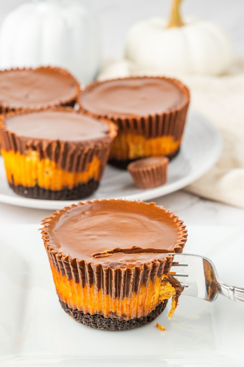 peanut butter cheesecake cupcake with a fork going into the dessert