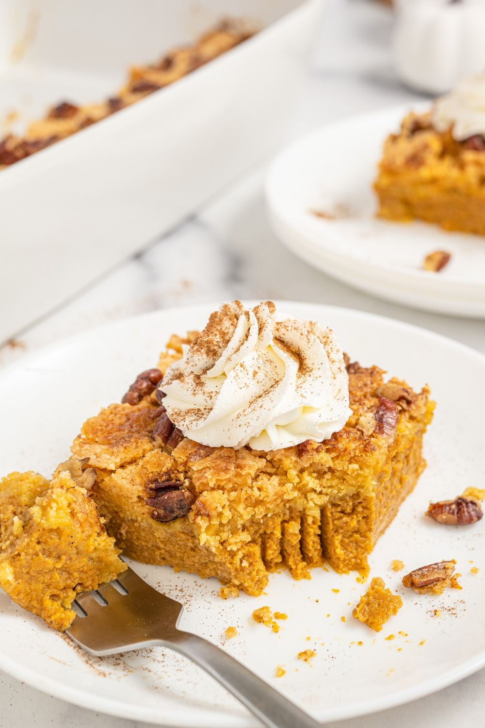 pumpkin cake with a bite taken out of slice sitting on a fork on plate