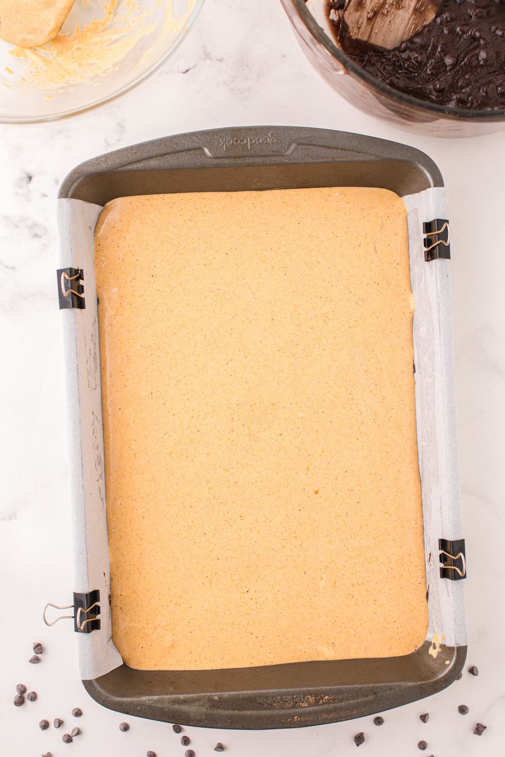 pumpkin cheesecake brownie batter in a pan