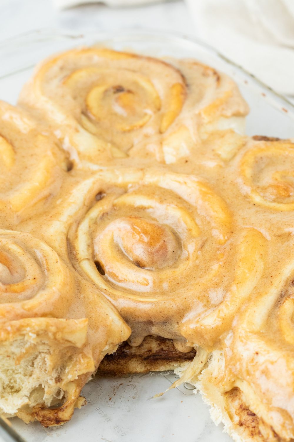 pumpkin cinnamon roll with a roll missing from the pan