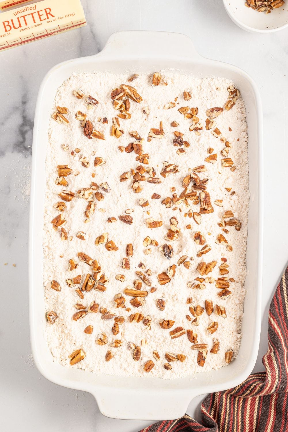 dry cake mix topped with nuts in a 9x13 baking dish