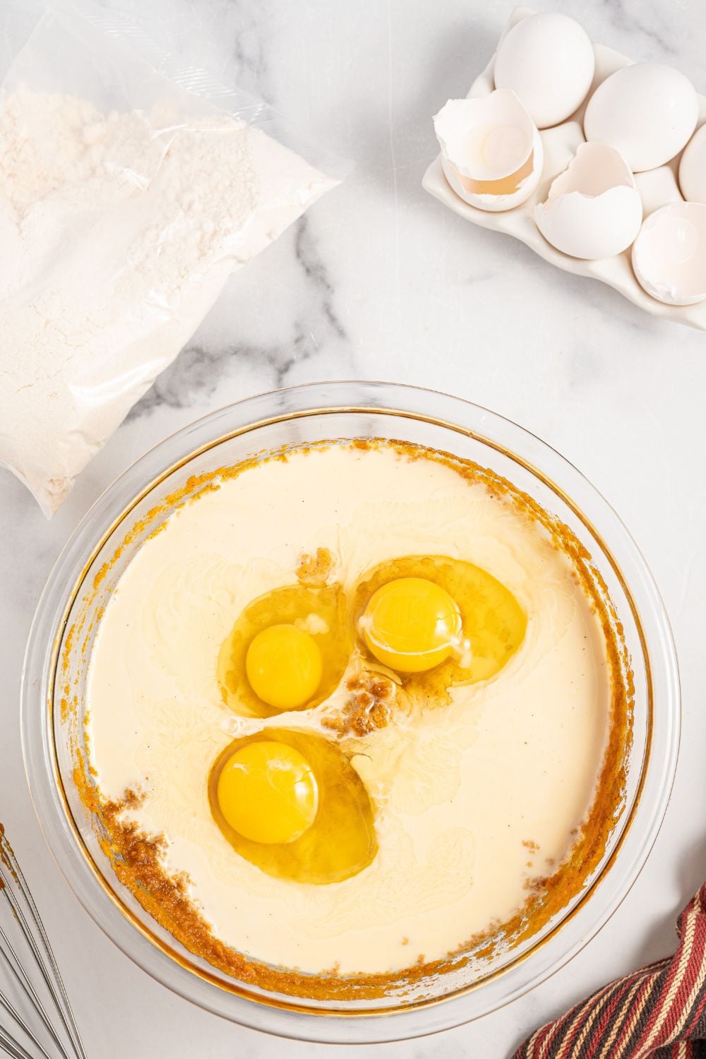 pumpkin cake mixture in bowl with eggs and evaporated milk