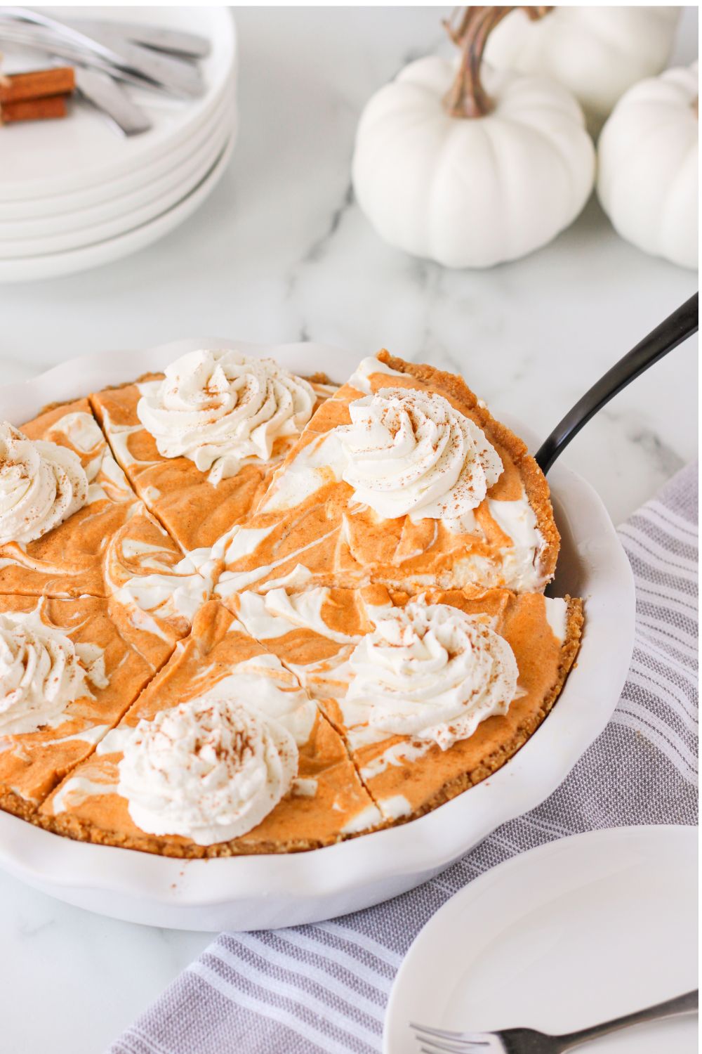 pumpkin pie ice cream cake in a pan with a spatula in one side to lift slice out