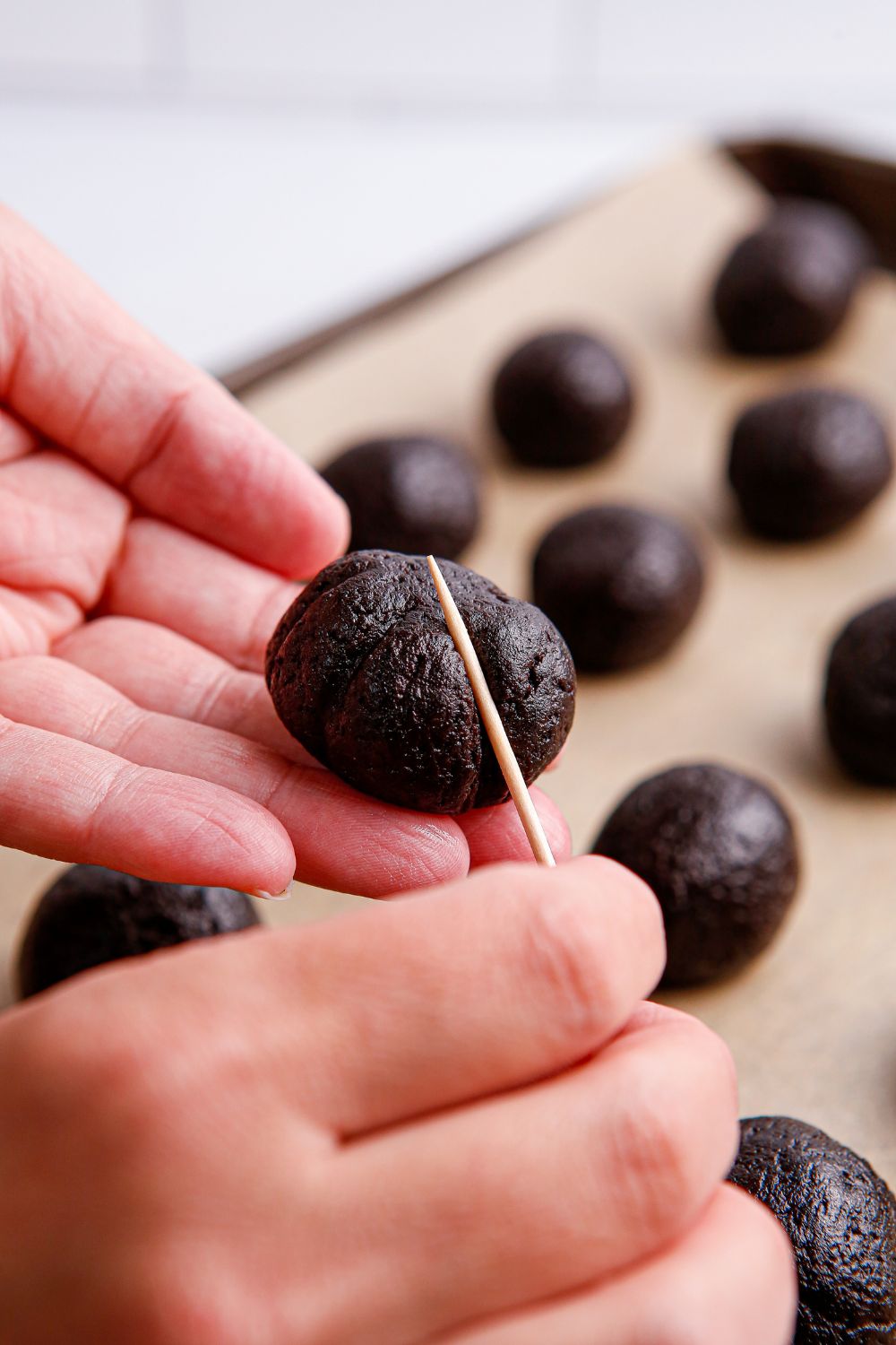 toothpick pressing into an Oreo ball