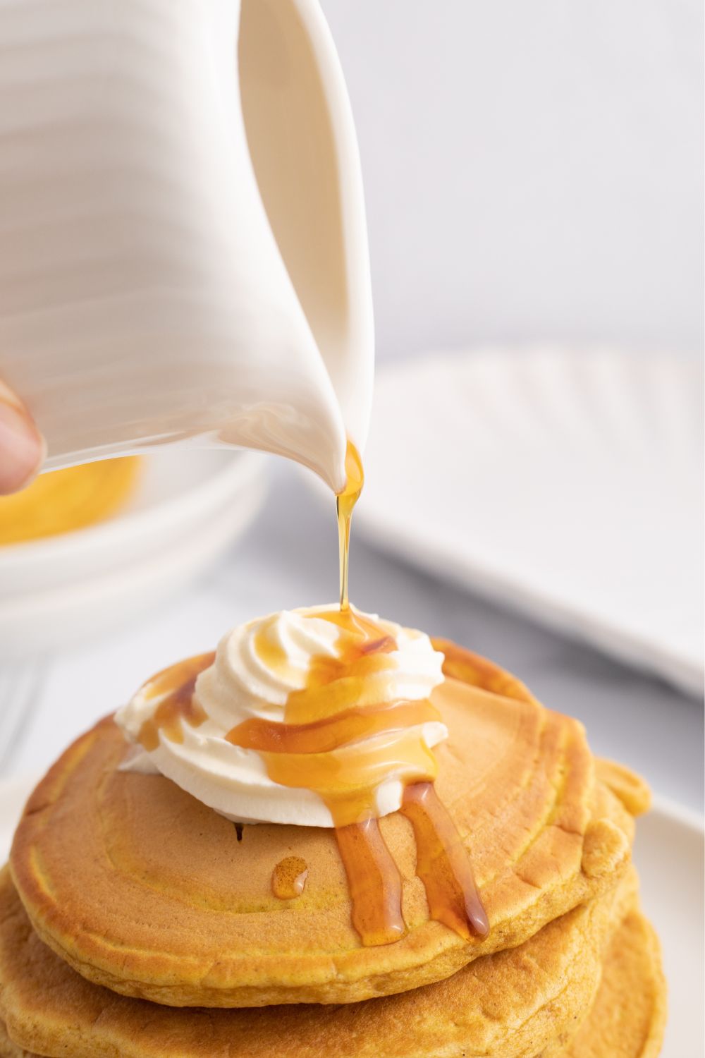 syrup being poured on top of pancakes