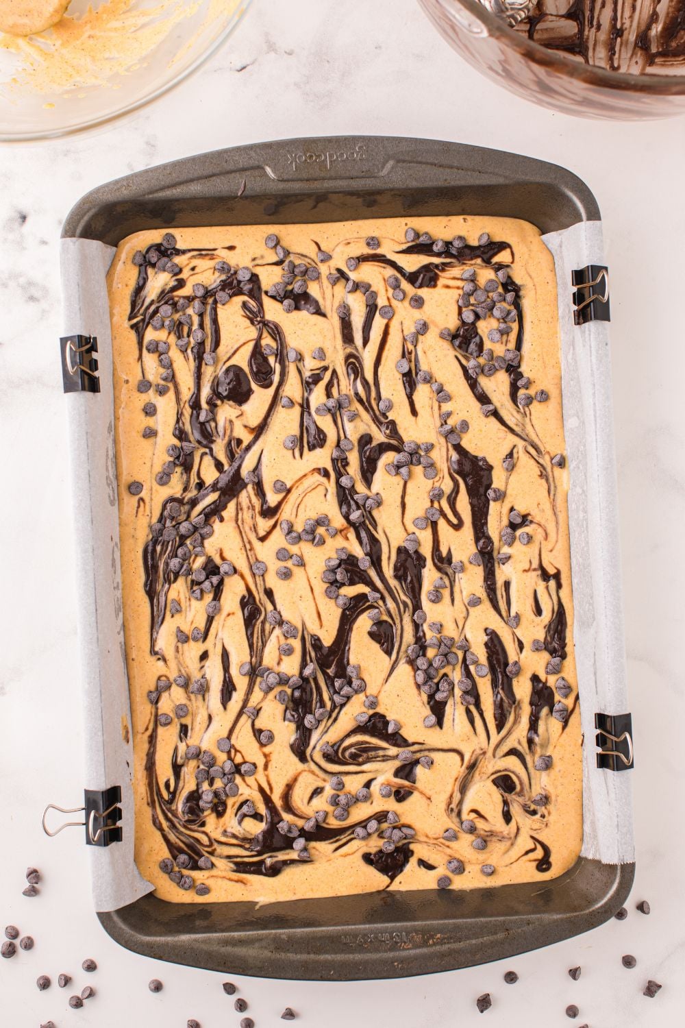 Pumpkin Brownies swirled in a pan with chocolate chips on top